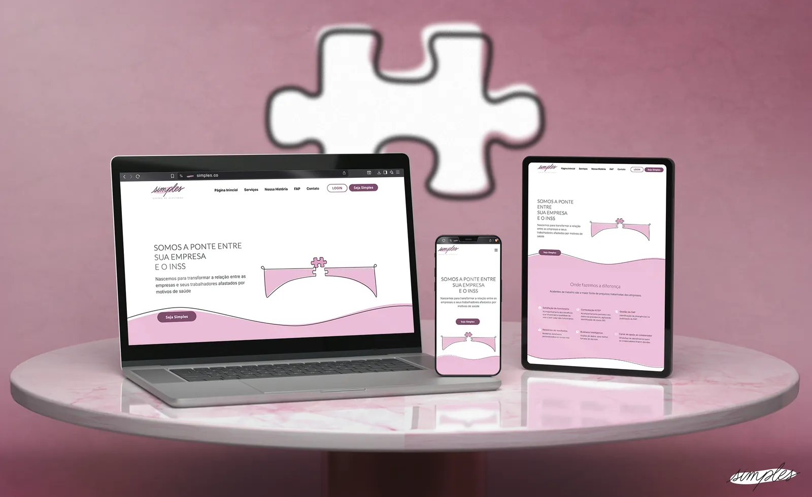 Site da Simples num notebook, num tablet e num celular, sobre uma mesa rosa.